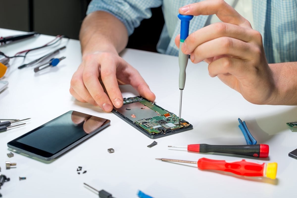Elektroniktechniker repariert ein Mobiltelefon unter dem Mikroskop
