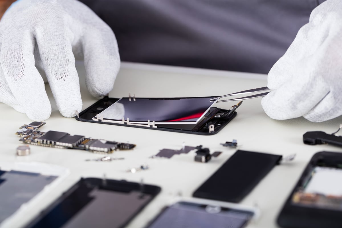 Techniker repariert ein iPhone mit der Pinzette – iPhone Reparatur Rosenheim